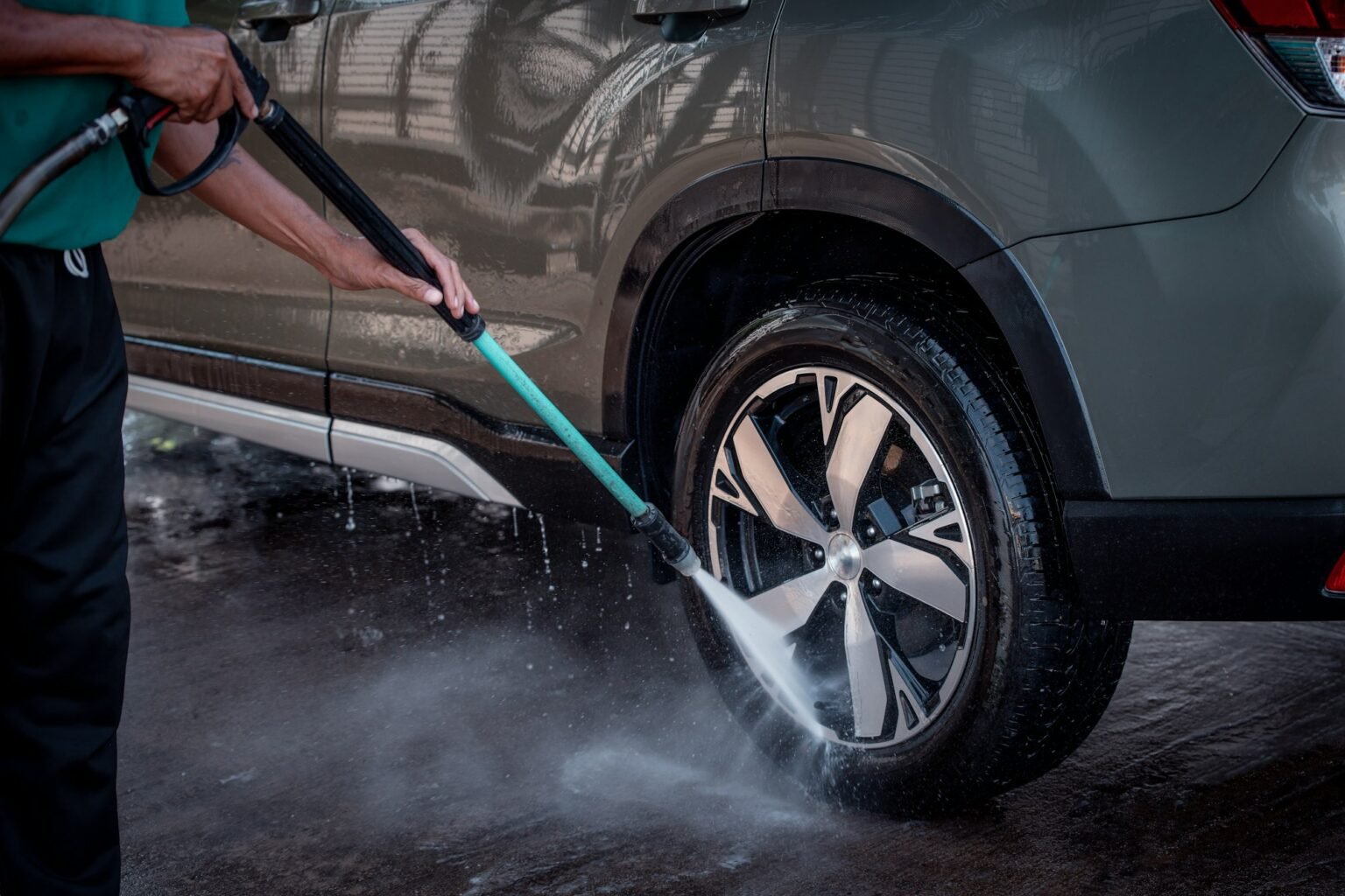 Worker cleaning car alloy wheels