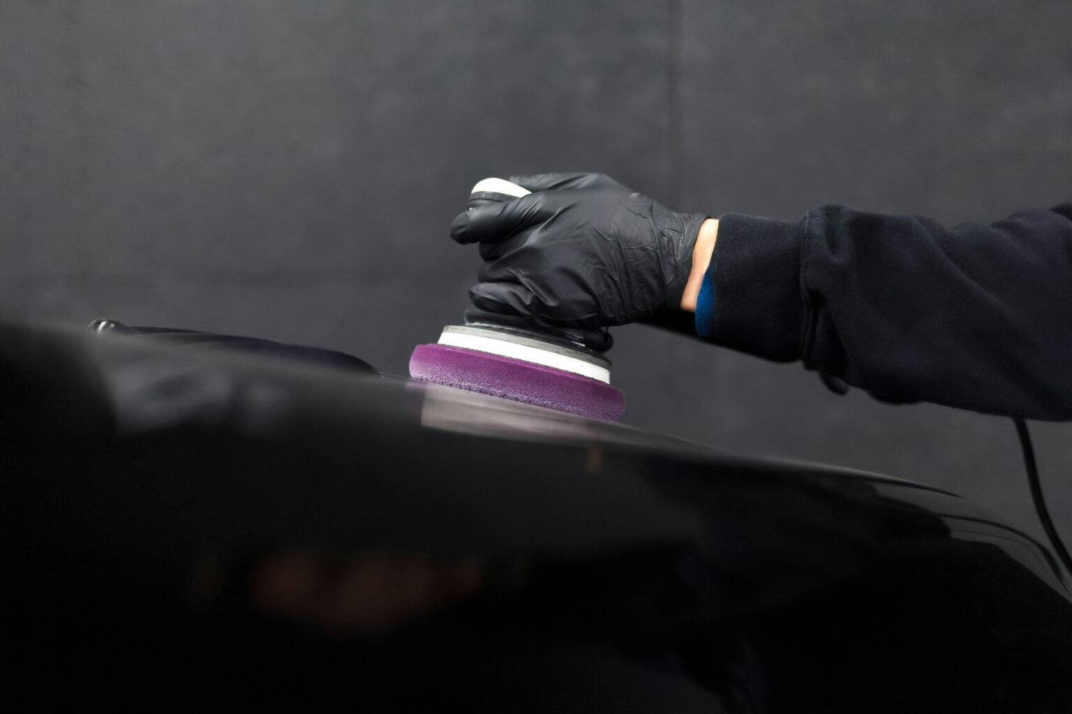 Detailing professional using polishing machine